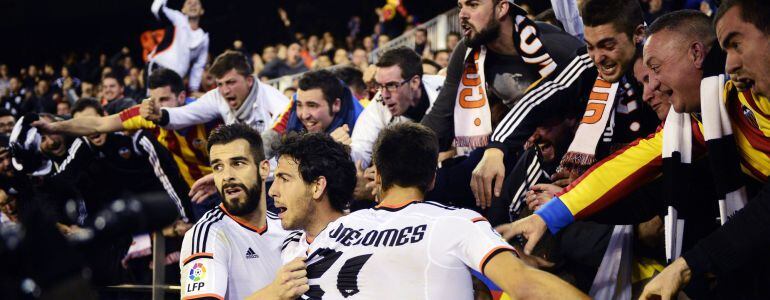Valencia's midfielder Dani Parejo (C) celebrates his second goal with teammates and fans during the Spanish league football match Valencia vs Sevilla at Mestalla stadium in Valencia on January 25, 2015. AFP PHOTO / JOSE JORDAN