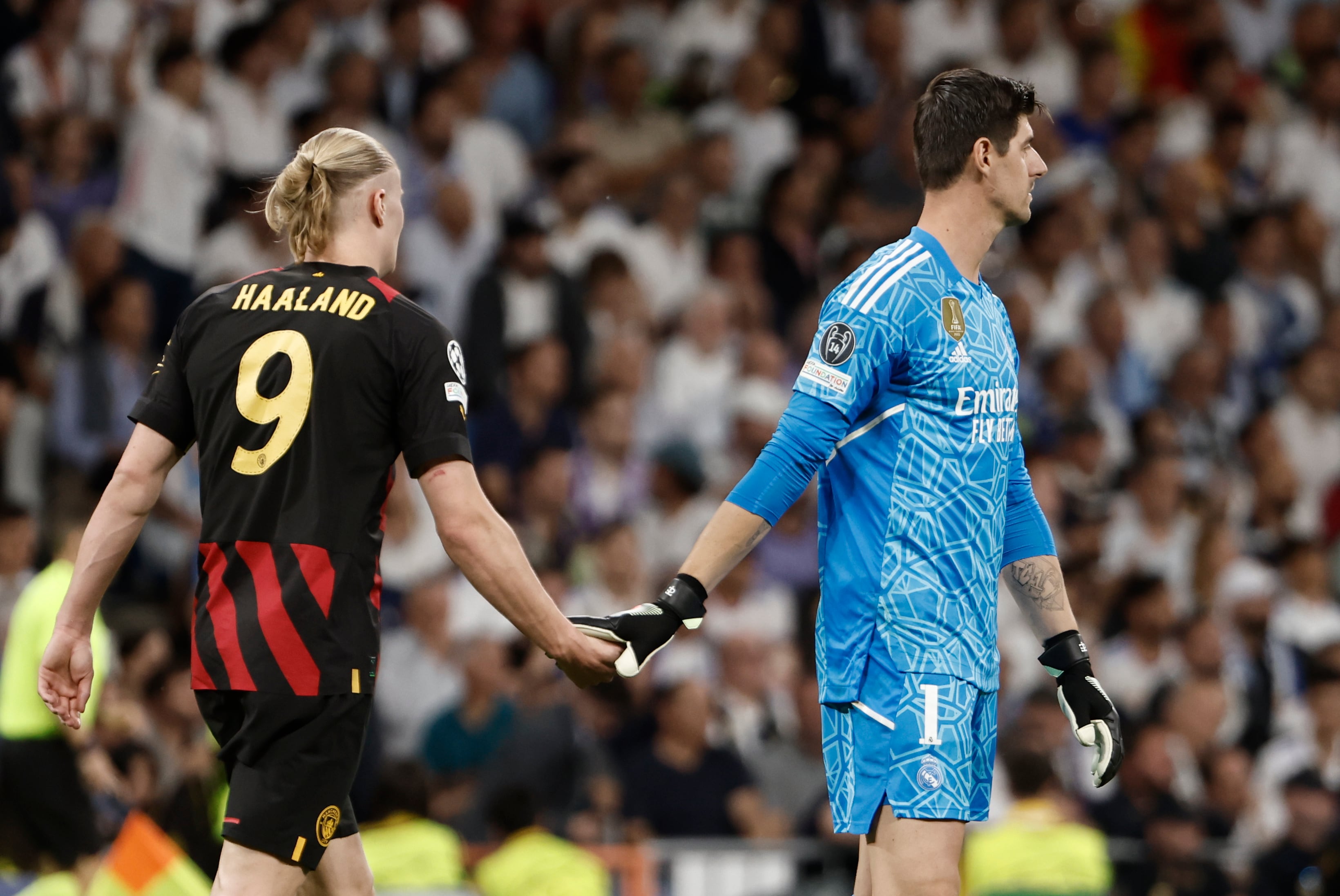 Thibaut Courtois y Erling Haaland, se saludan a la finalización del encuentro correspondiente a la ida de las semifinales de la Liga de Campeones que han disputado hoy martes en el estadio Santiago Bernabéu