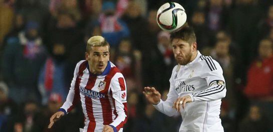 Sergio Ramos despeja el balón con la cabeza ante la presencia de Griezmann