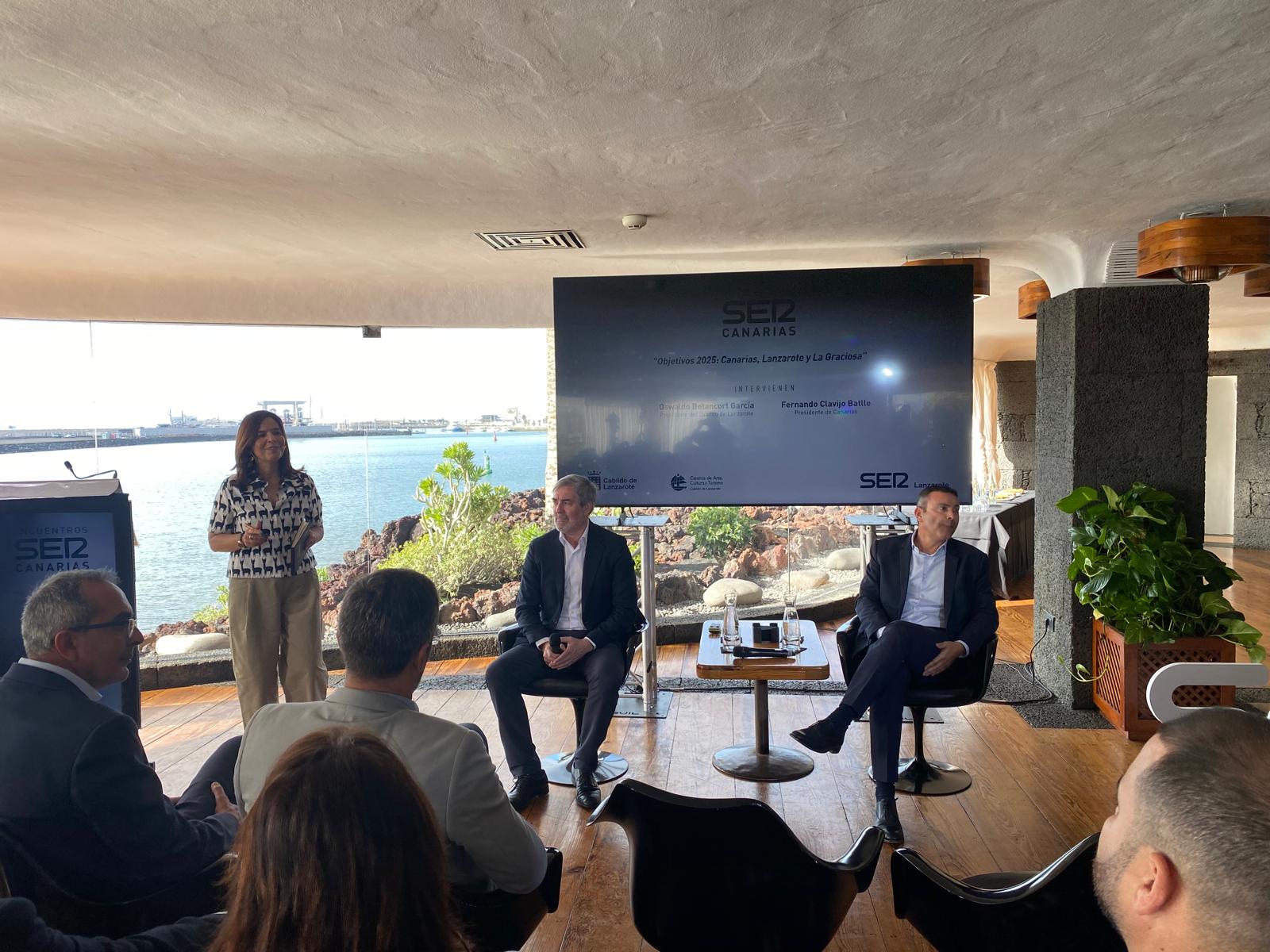 El presidente del Gobierno de Canarias, Fernando Clavijo, sentado junto al presidente del Cabildo de Lanzarote, Oswaldo Betancort, y en la presentación del Encuentro SER Canarias por parte de la directora del Grupo Prisa en el Archipiélago, Lourdes Santana.