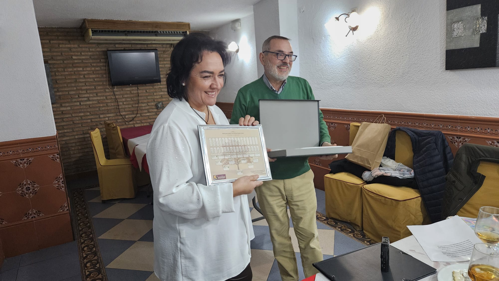 La pregonera muestra el regalo conmemorativo, en presencia de Ildefonso Alcalá