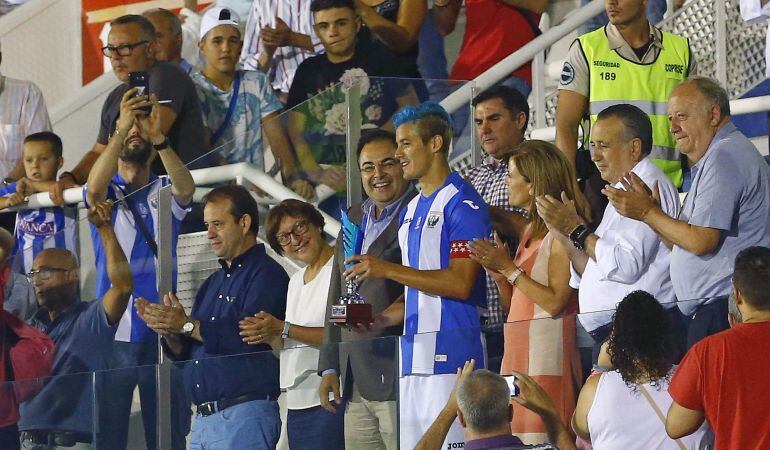El defensa argentino del Leganés Martín Mantovani recibe el trofeo Ciudad de Leganés junto a la presidenta y el alcalde de la ciudad