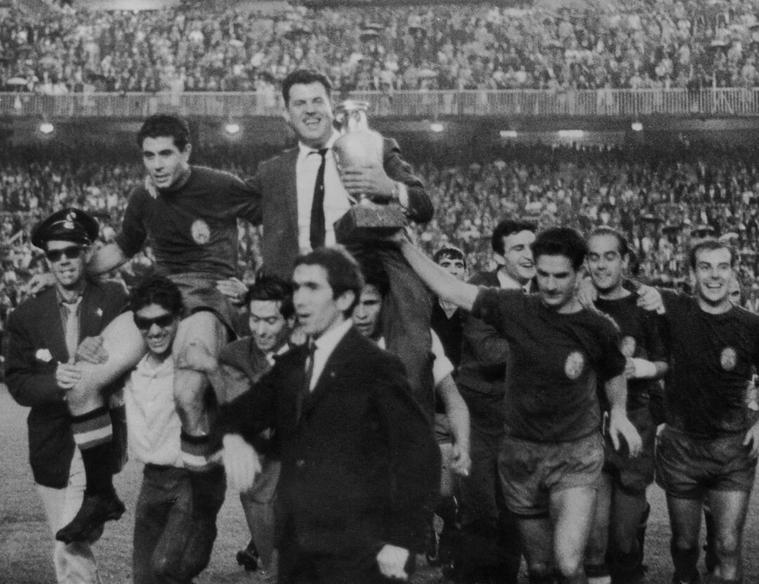 Rivilla, a la derecha, con una mano en el trofeo de la Eurocopa 1964, que porta el seleccionador José Villalonga