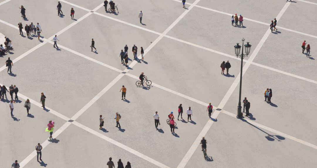 Imagen aérea de un grupo de presonas caminando por una plaza. 