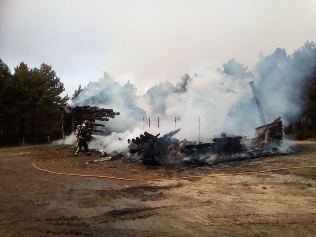 Un bombero extingue las llamas de la caseta del Centro del Lobo de Robledo