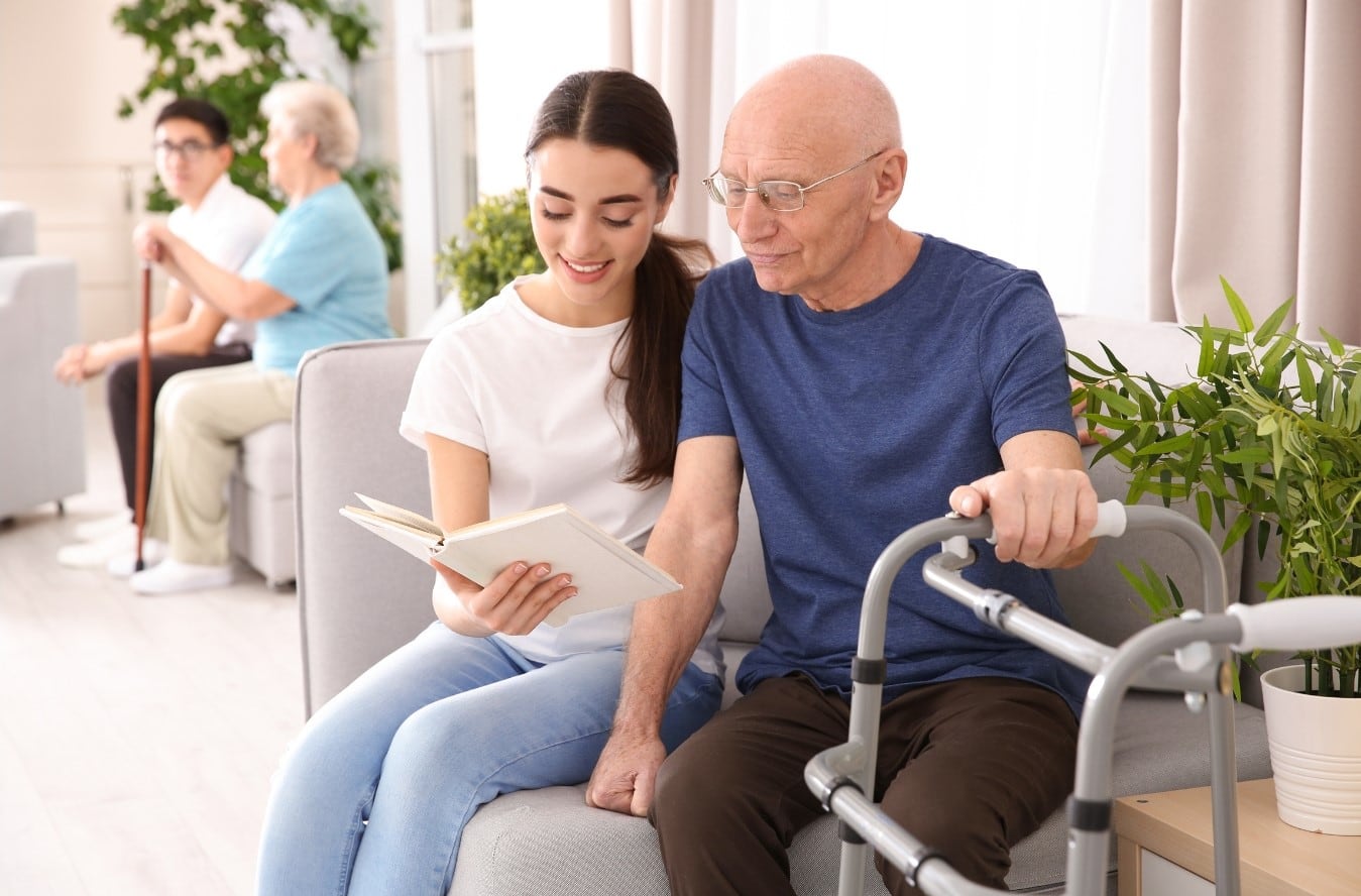 Voluntaria leyendo a una persona mayor