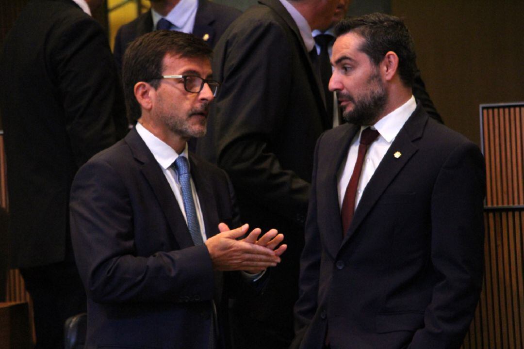 El ministre de Finances, Jordi Cinca, conversa amb el conseller demòcrata, Marc Ballestà, abans de l'inici de la sessió de Consell General d'aquest dijous.