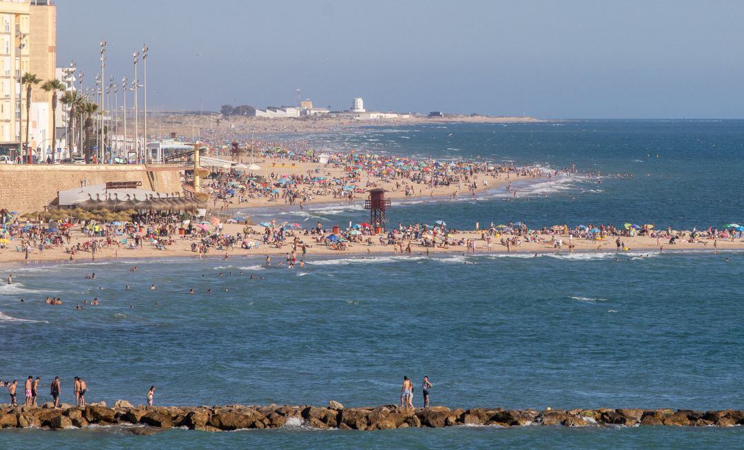 CÁDIZ, SPAIN - JUNE 27: Many people crowd together on the beach to enjoy the hot weather on the beach of Santa María del Mar