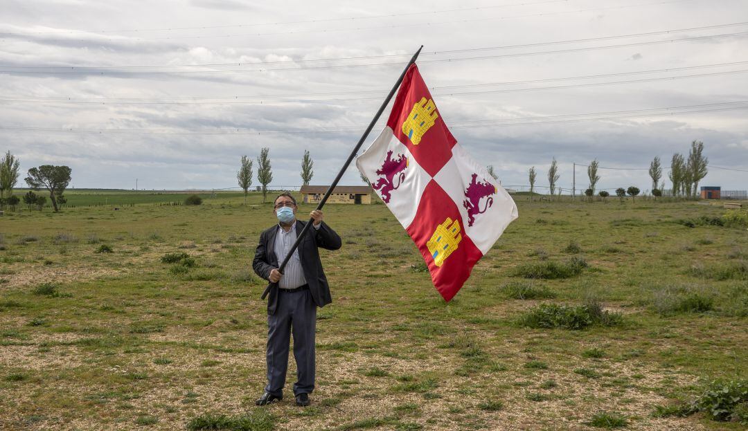 El alcalde de Villalar, Luis Alonso Laguna, sostiene una bandera de Castilla y León en una campa vacía