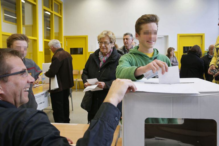 Adolescent de 16 anys dipositant avui una butlleta a una urna per primer cop