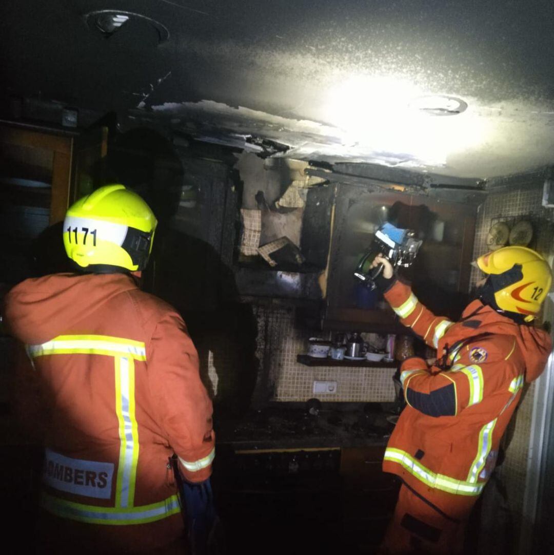 Los bomberos revisan los daños en la vivienda afectada por el fuego en Oliva. 