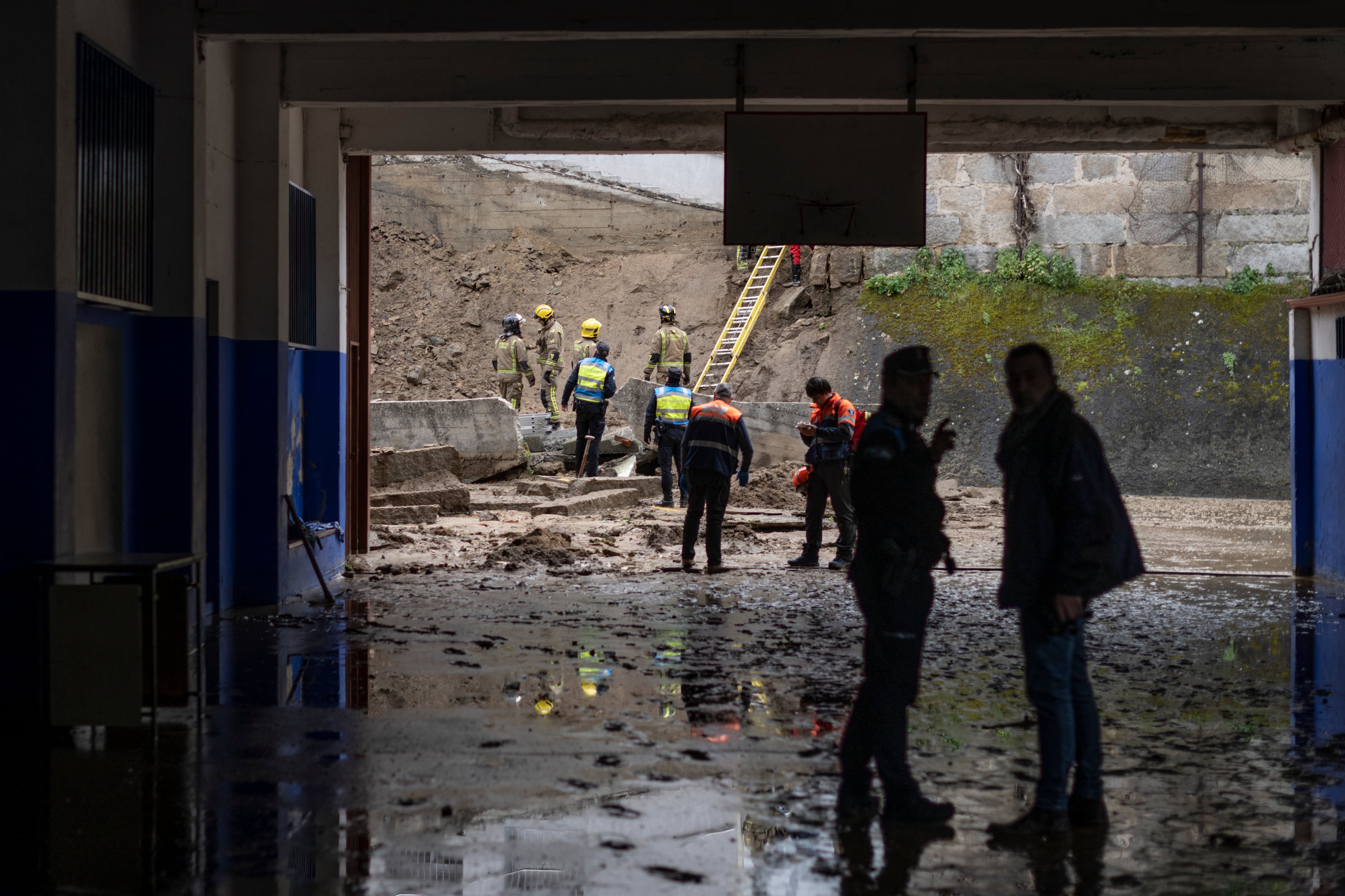 Efectivos de de bomberos y policía local inspeccionan el estado del patio del colegio Cardenal Cisneros de Ourense ayer miércoles, donde se desplomó un muro. EFE/ Brais Lorenzo