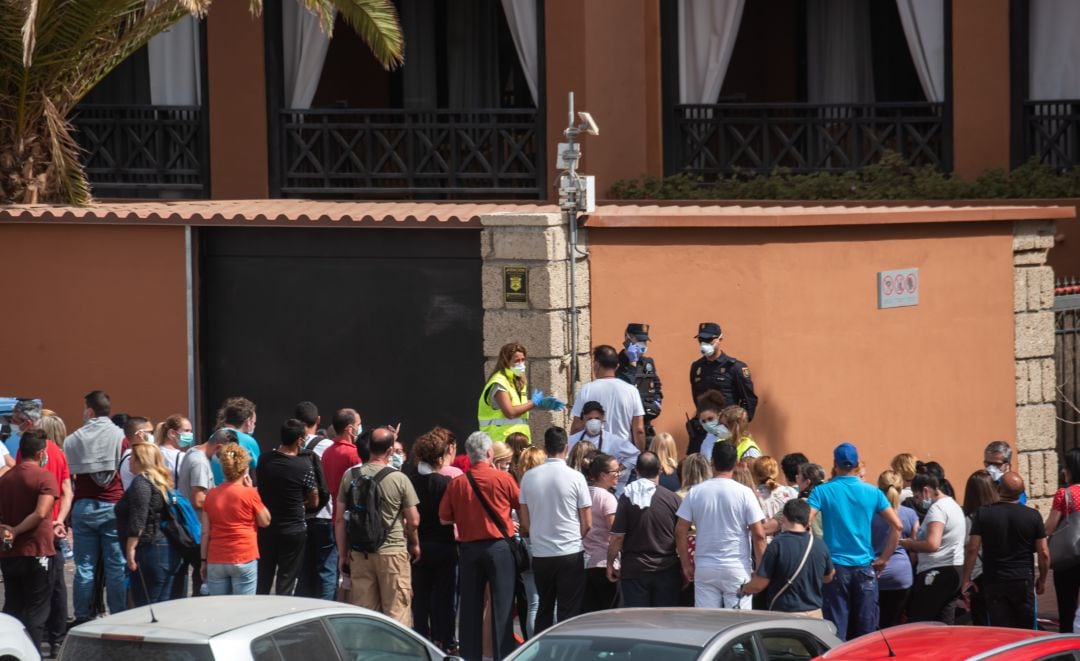 Un grupo de psicólogos habla con trabajadores fuera del hotel. 