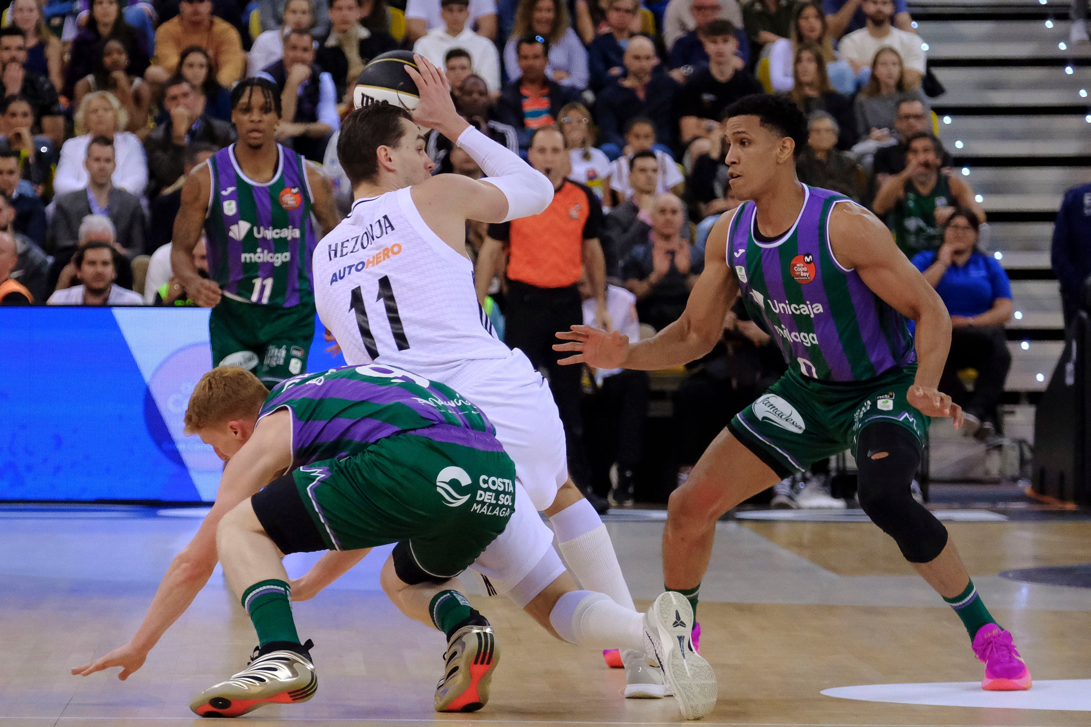 LAS PALMAS DE GRAN CANARIA, 16/02/2025.- El alero croata del Real Madrid Mario Hezonja (c) lucha con Alberto Díaz (i) y con Tyson Pérez, ambos del Unicaja, durante la final de la Copa de Rey de baloncesto que Real Madrid y Unicaja Málaga disputan este domingo en el Gran Canaria Arena, en Las Palmas de Gran Canaria. EFE/ Angel Medina G.
