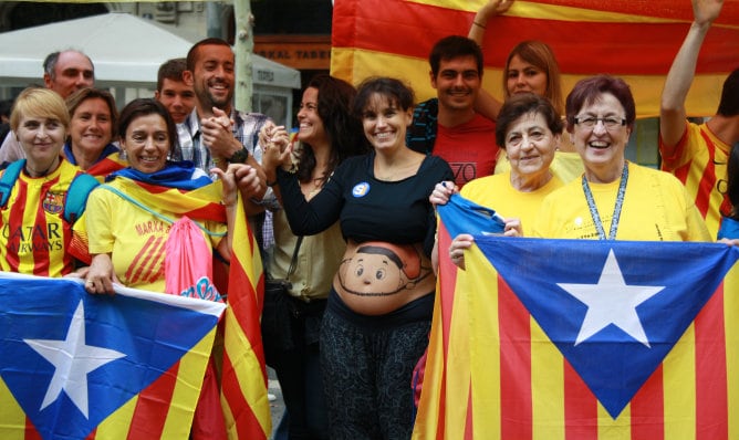 Algunos de los participantes de la &#039;Vía Catalana por la independencia&#039; vestidos con camisetas amarillas y sosteniendo banderas para la ocasión