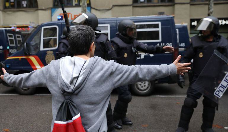 Un joven frente a varios agentes de Policía durante el 1-O