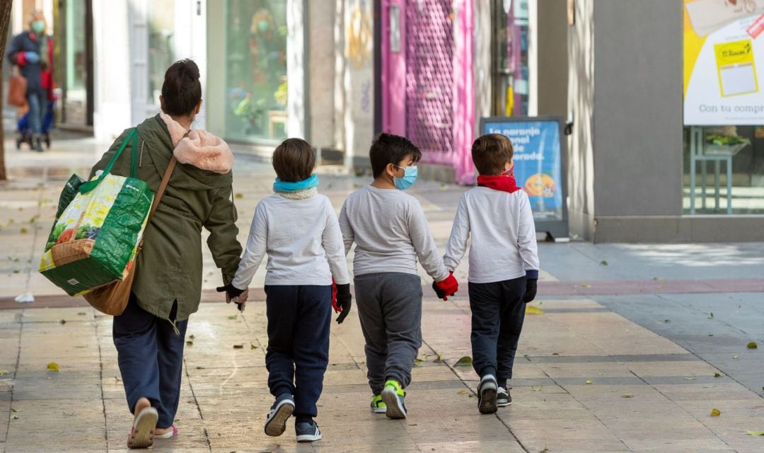 Una madre y sus hijos salen a hacer la compra en Zaragoza.