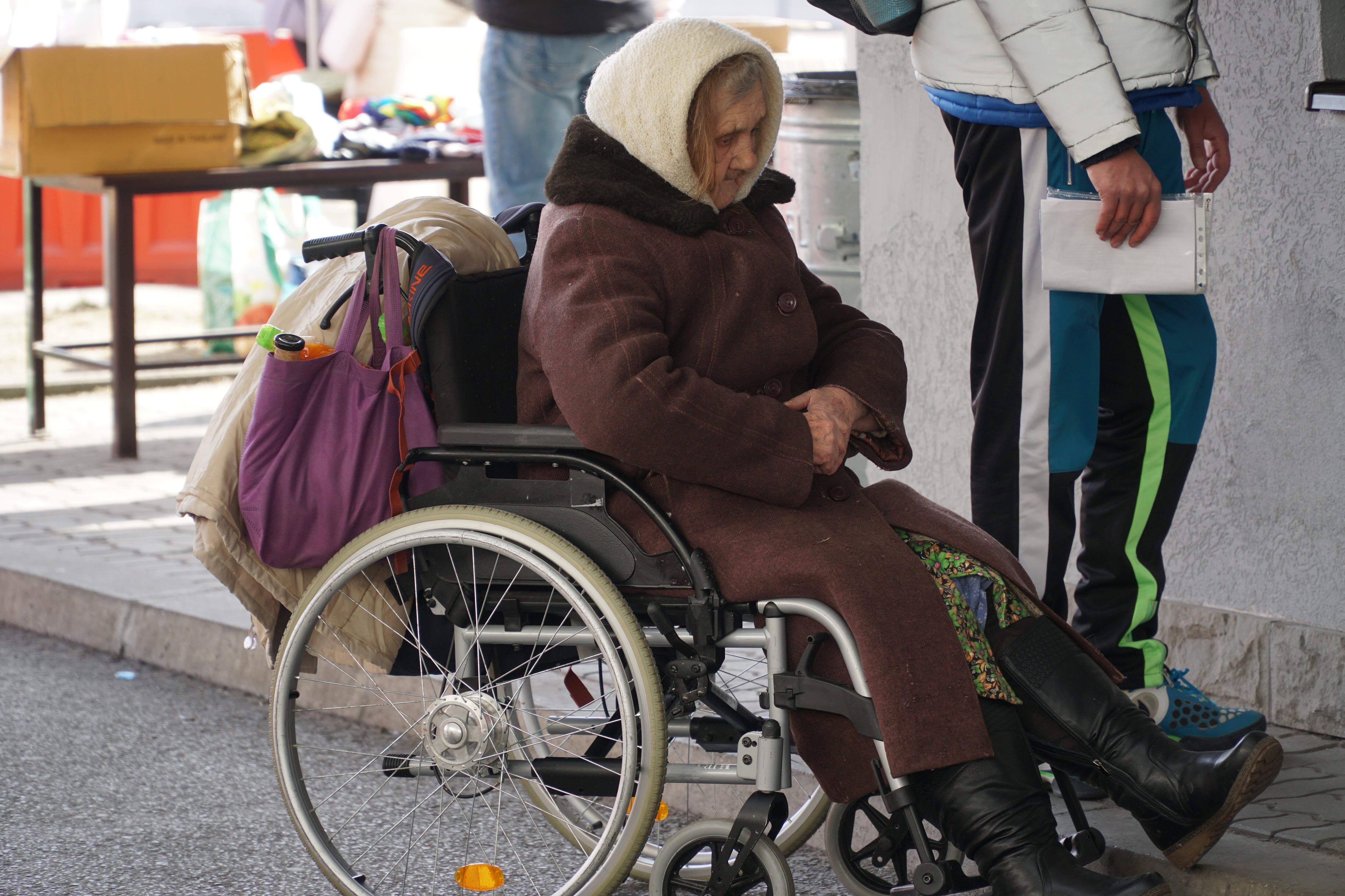 GRAF8461. KORCZOWA (POLONIA), 14/03/2022.- Una anciana esperando en el punto de registro de entrada de refugiados ucranianos en el paso de Korczowa, en Polonia. Las temperaturas bajo cero y el riesgo de huir de zonas asediadas en Ucrania por las tropas rusas reduce los flujos de llegada a la frontera polaca, pero las autoridades locales piden a Europa ayuda y cooperación porque los bombardeos cerca de Polonia causarán nuevas olas de refugiados. EFE/ Imane Rachidi
