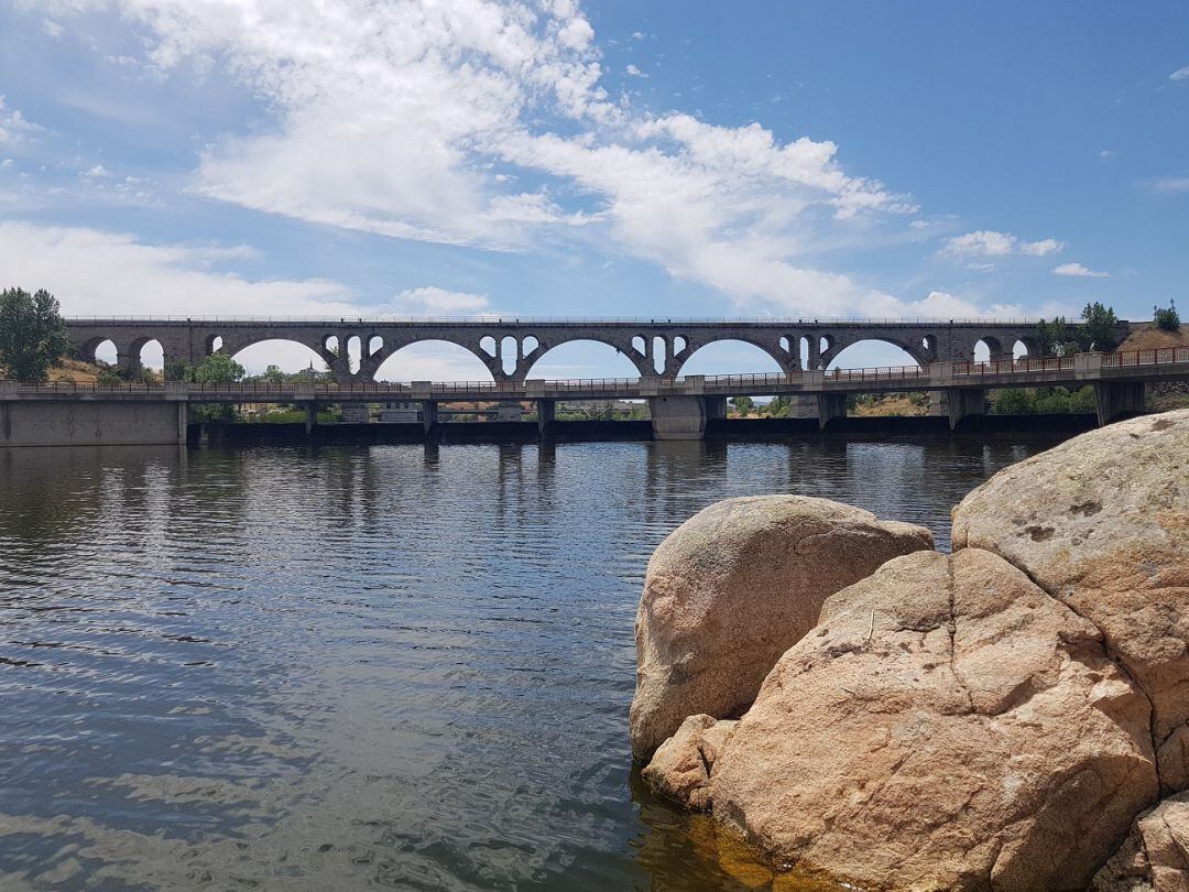 Vista panorámica de la presa de Fuentes Claras, con el puente de Salamanca al fondo 