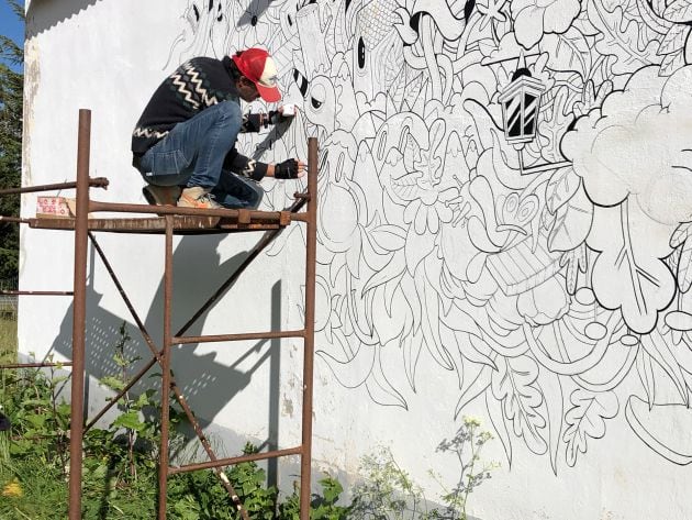 Óscar Llorens trabajando en el mural