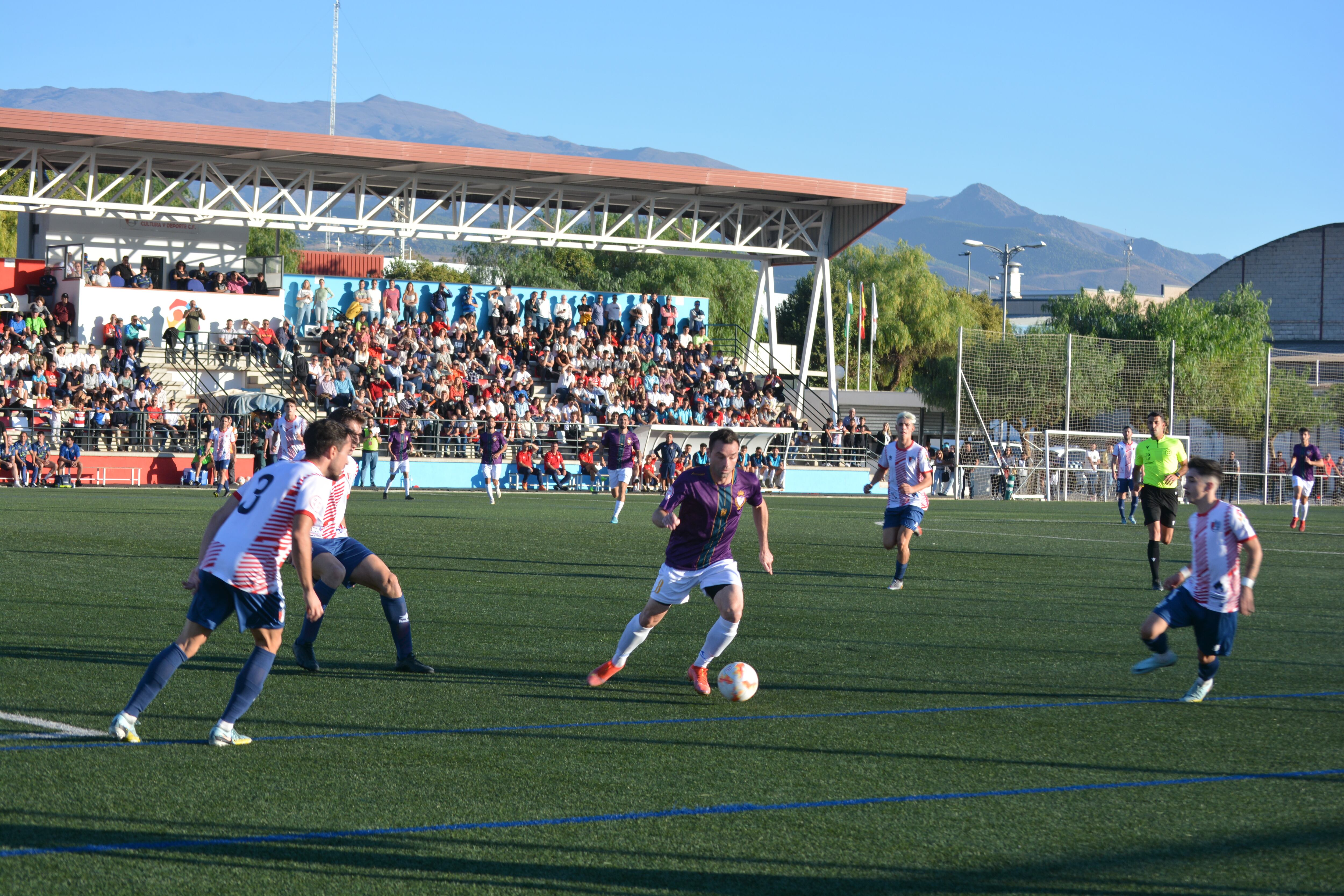 Urko Arroyo, uno de los jugadores destacados del partido, conduce el balón en medio de varios futbolístas locales