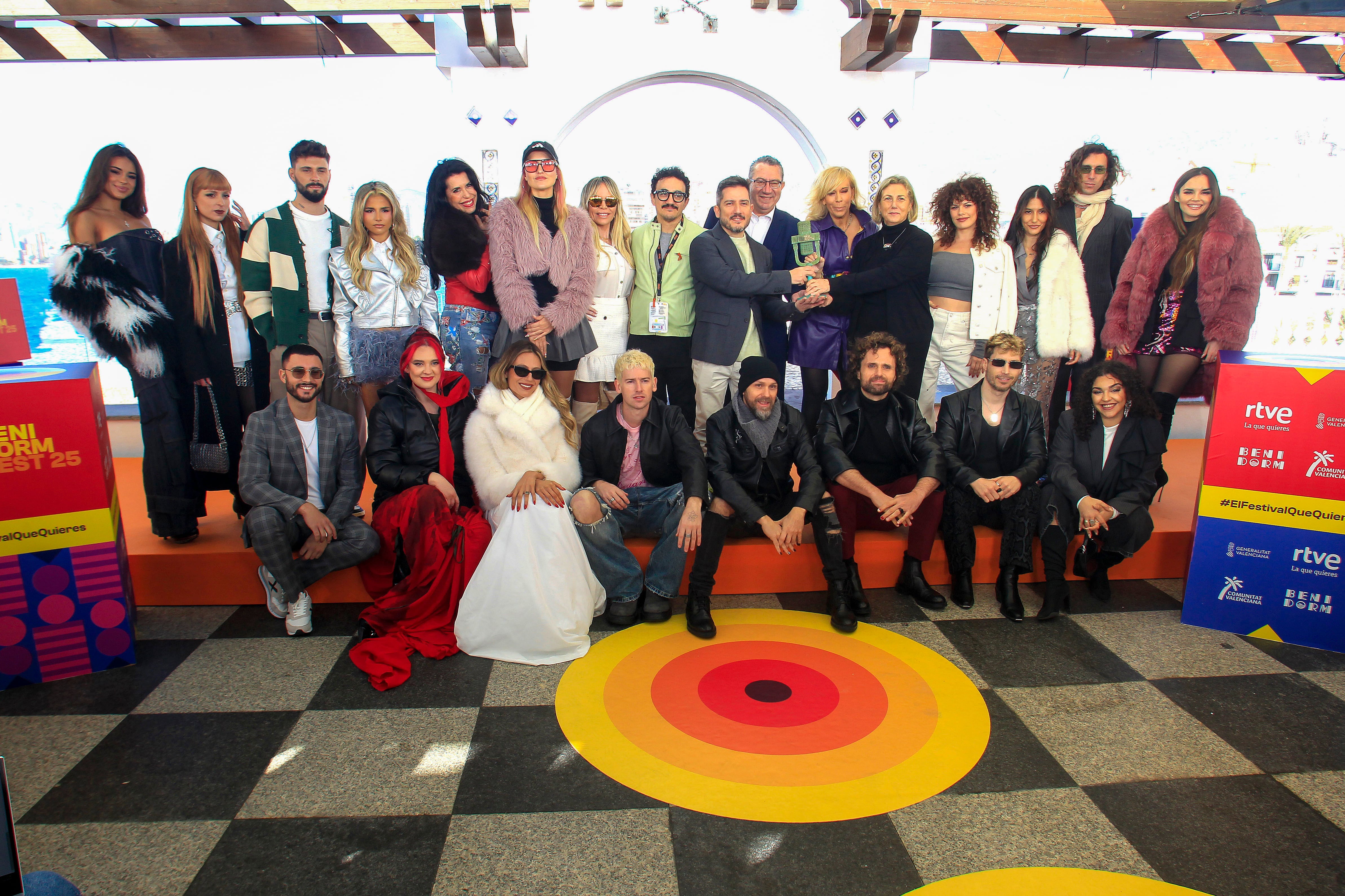 Los 16 participantes en Benidorm Fest 2025 posan con el con el alcalde de Benidorm, Toni Pérez (7º d), y representantes de RTVE durante la rueda de prensa ofrecida el lunes