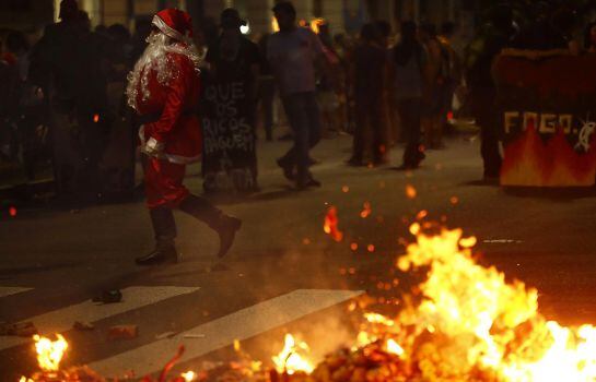 Un manifestante vestido como Santa Claus, junto a una barricada en Porto Alegre.