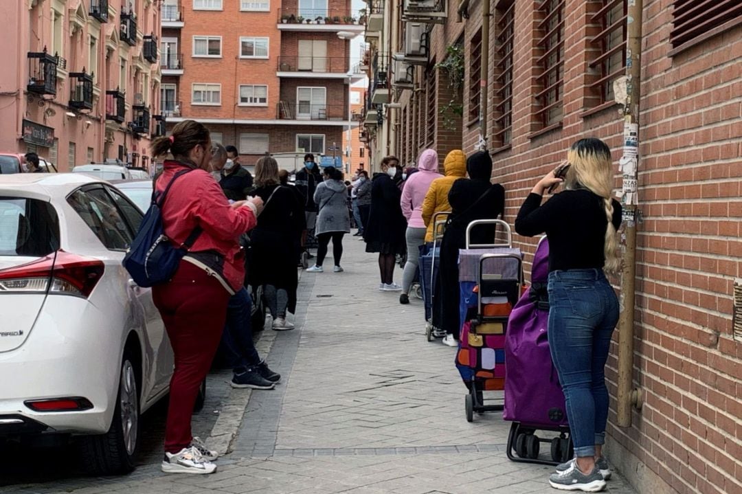 Vista de la fila de clientes que aguardan su turno para entrar al economato de Cáritas en el distrito madrileño de Tetuán.