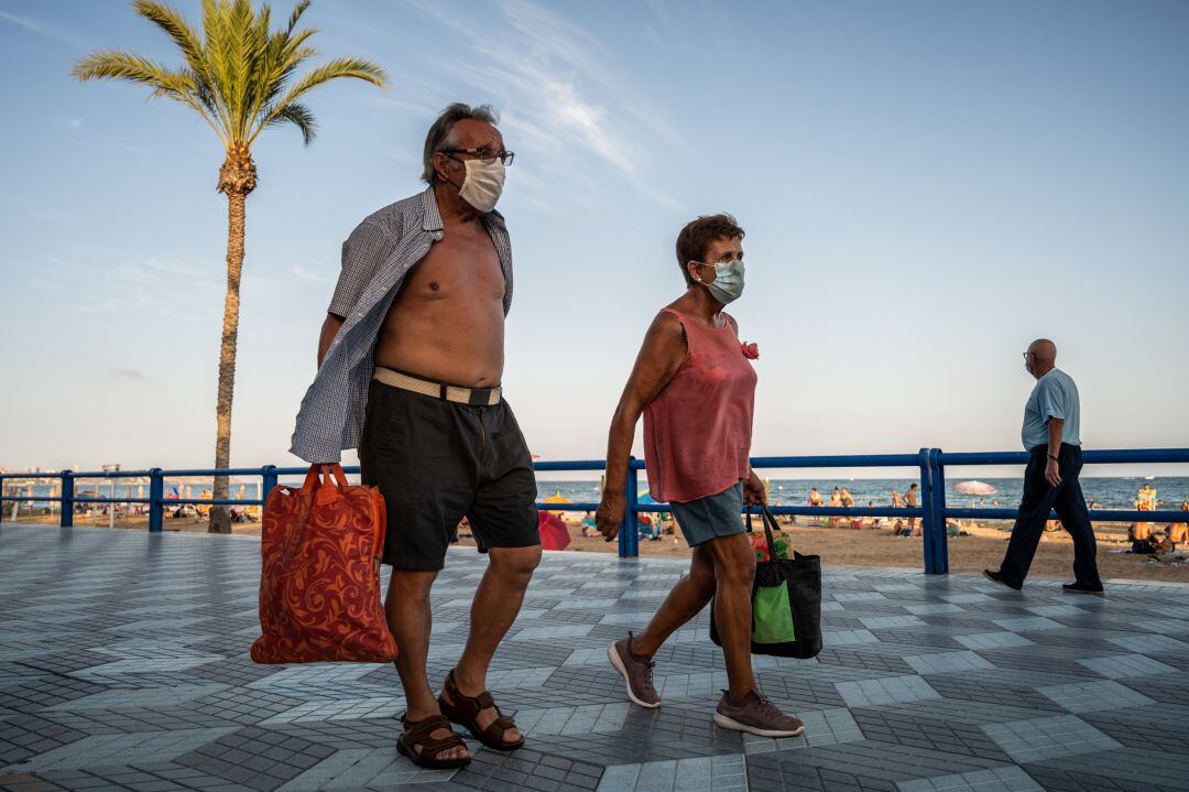 Dos personas pasean por un paseo marítimo durante el verano de 2020