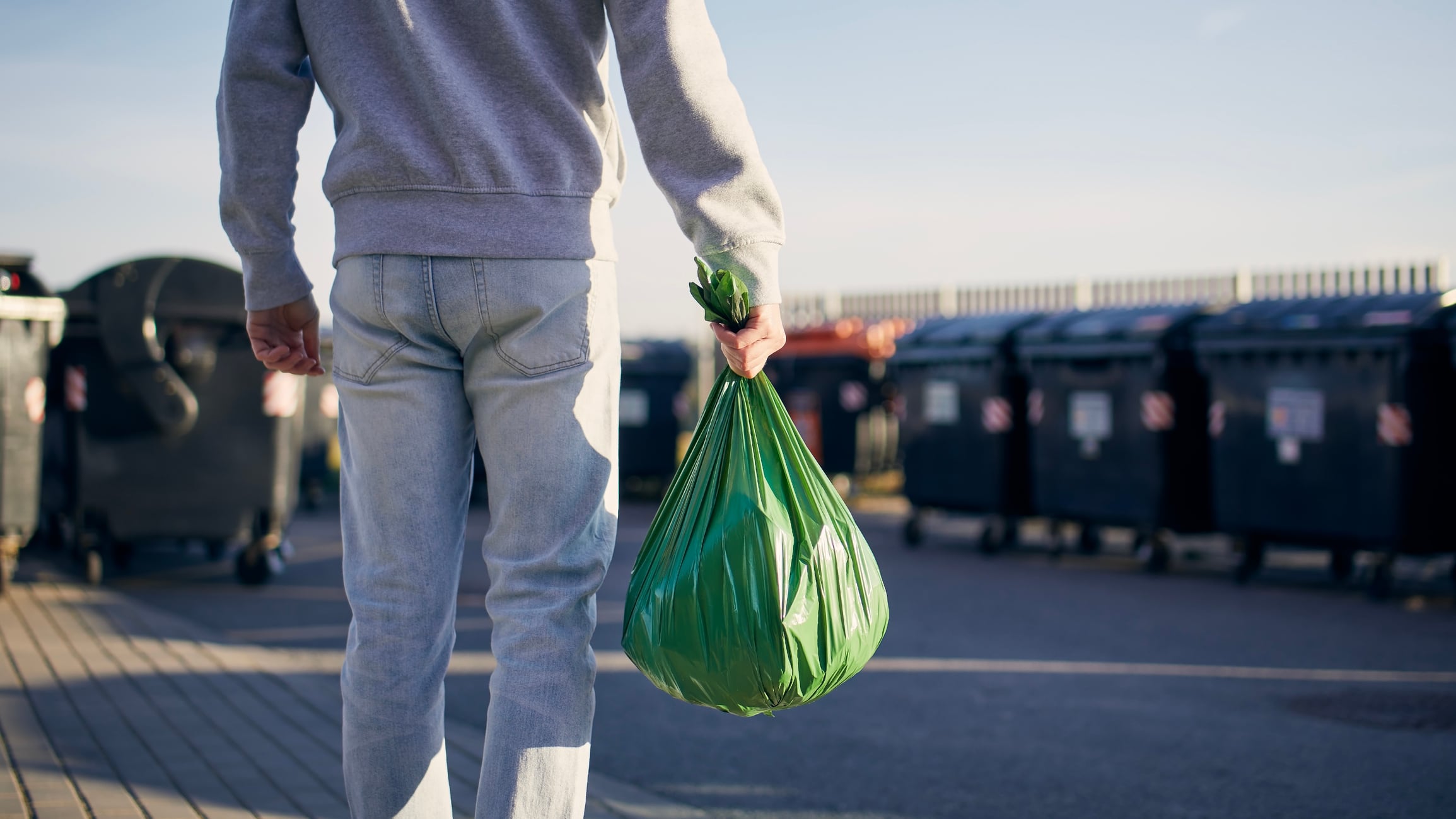 Un vecino con una bolsa de basura en la mano.