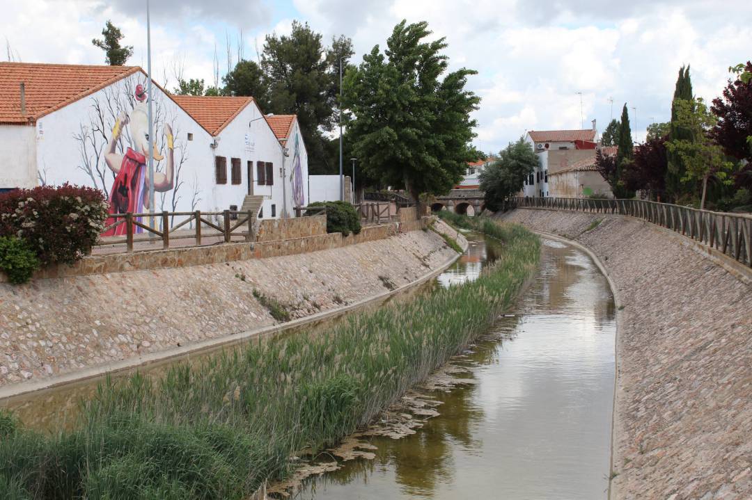 Vista del municipio desde el río y con uno de sus característicos murales de fondo