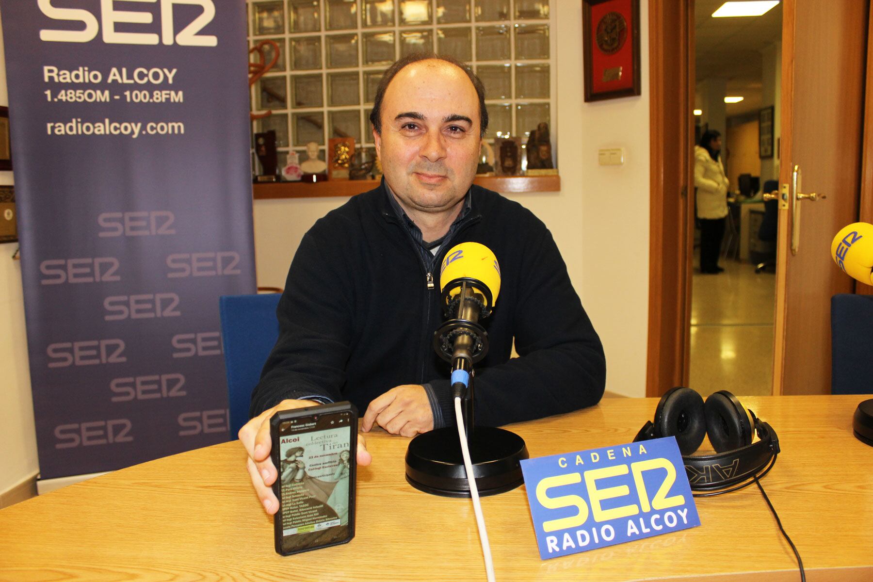 Francesc Gisbert mostra al mòbil el cartell que anuncia una nova edició de la Lectura col·lectiva del Tirant