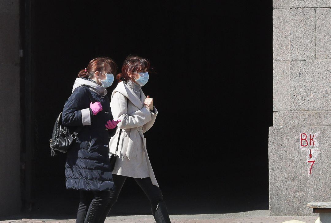 Dos mujeres, protegidas con máscarillas, caminan por una calle de Euskadi