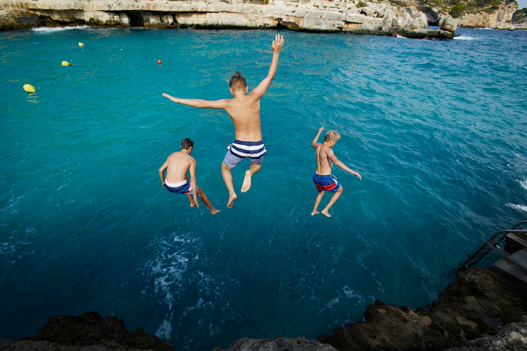 Varios niños saltando al agua.