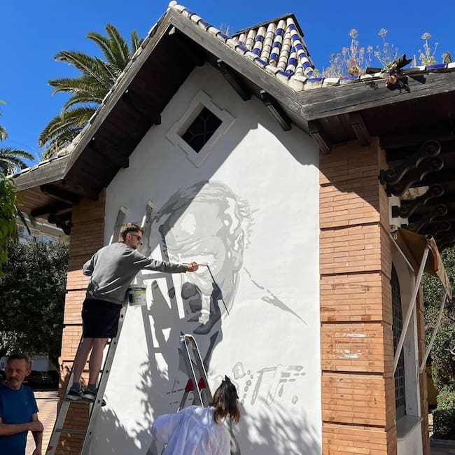 Artista trabajando en la pintura mural en homenaje al célebre guitarrista Diego del Gastor