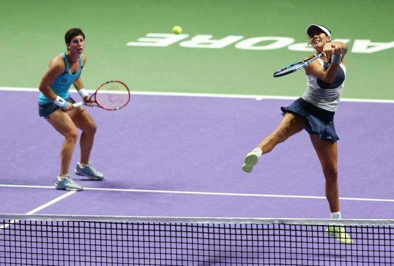 Garbiñe Muguruza remata ante la atenta mirada de Carla Suárez.