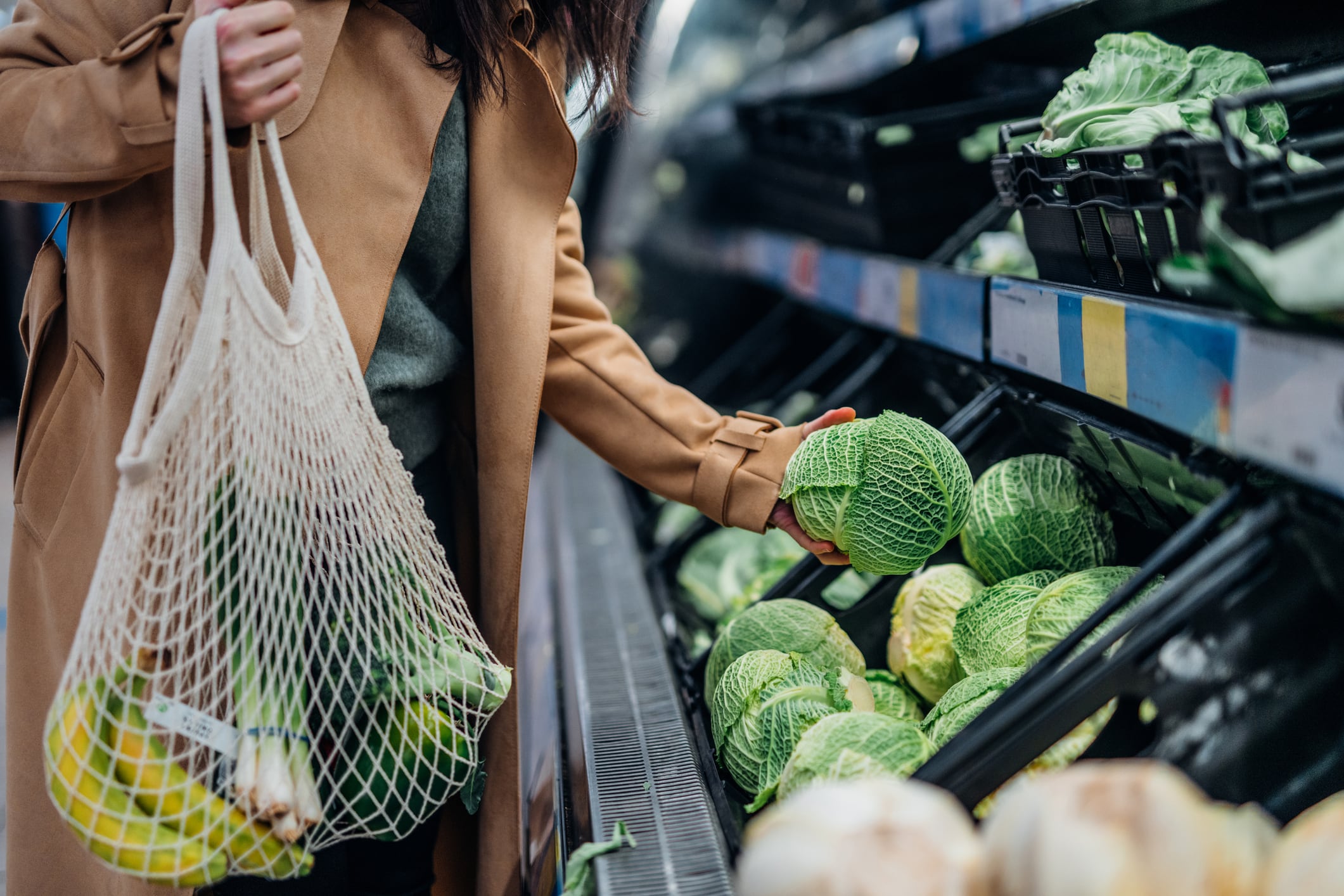 Dona comprant fruites i verdures ecològiques fresques al supermercat