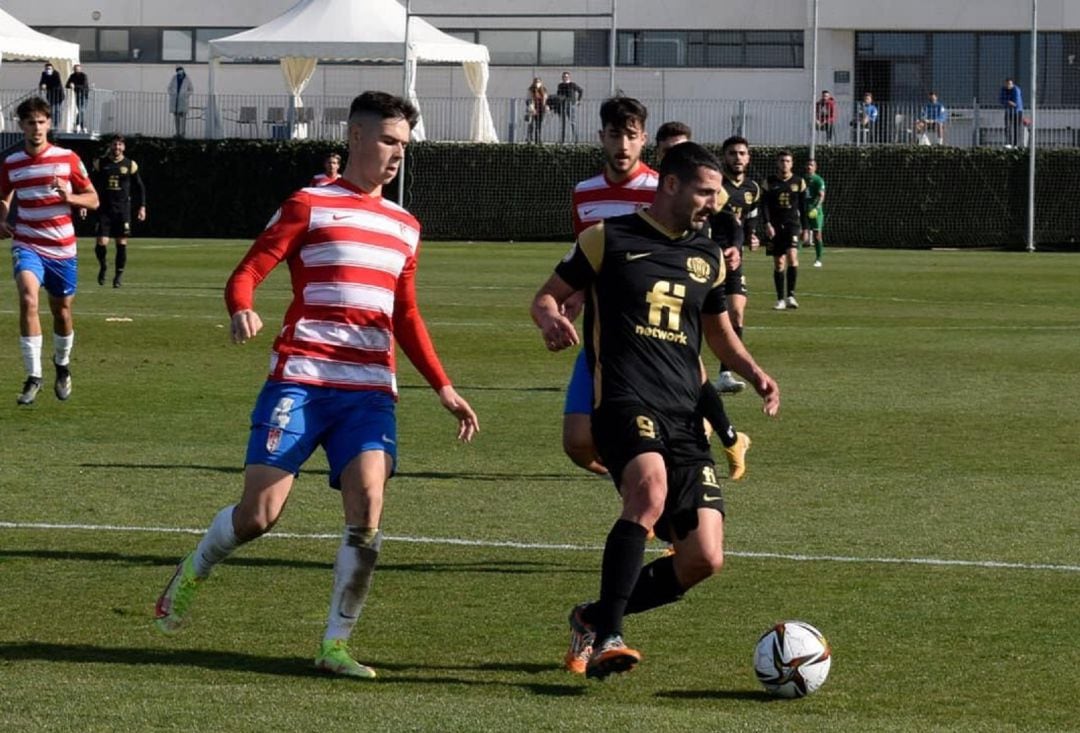 Manuel Salinas controla el balón ante un futbolista del Recreativo Granada 