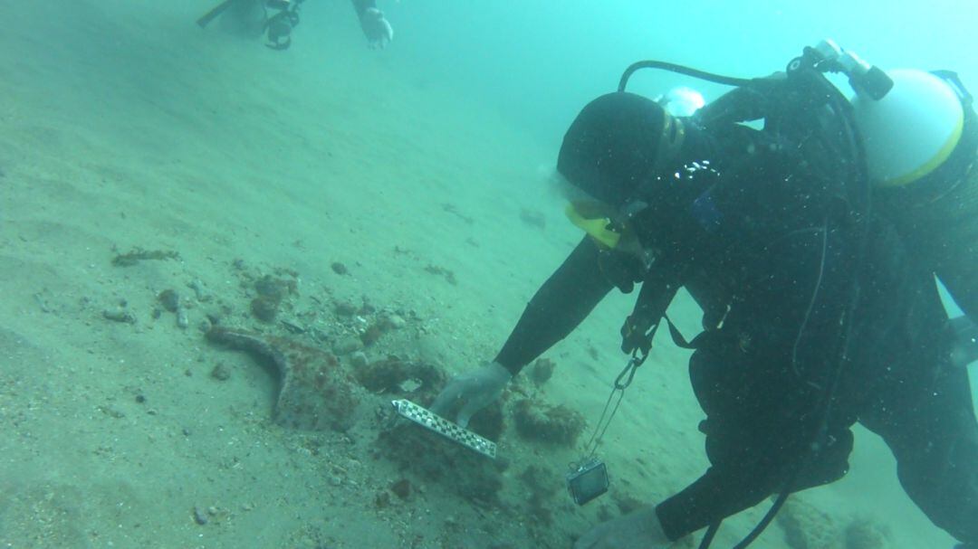 Un buceador en plena extracción de una pieza arqueológica en el fondo del mar.