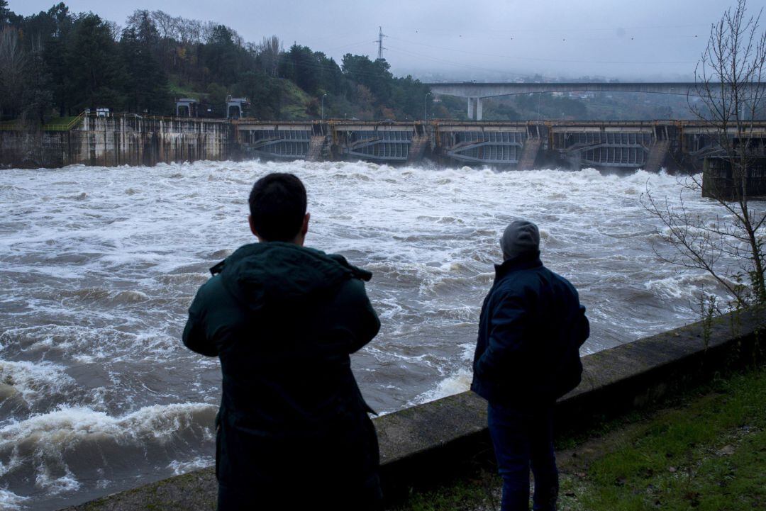 Las lluvias continuadas mantienen en situación de alerta a la provincia de Ourense después de copiosas precipitaciones registradas en la última semana, especialmente por la crecida del río Miño, cuyo caudal se ha multiplicado por siete en apenas unos días. En la imagen, dos hombres observan la fuerza del Miño a su paso por el embalse de Velle. 