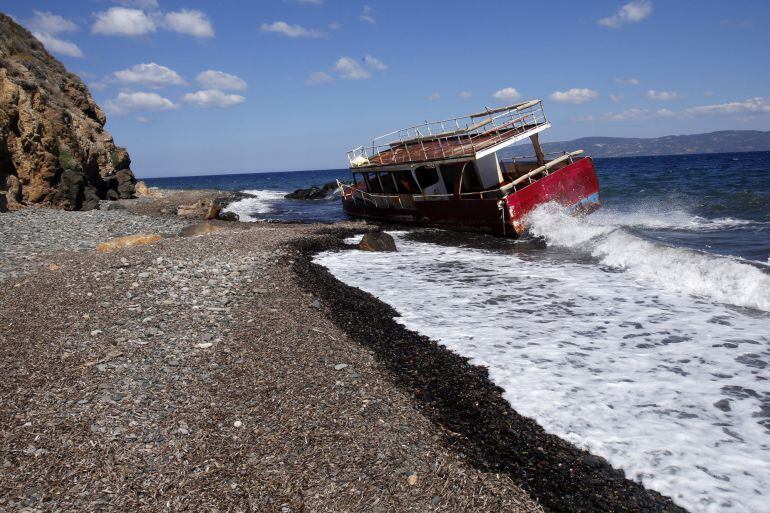 Los restos destrozados de un pequeño barco en la orilla de la playa de Skala Kaminas que fue utilizado por los refugiados que cruzan el mar Egeo de Turquía a Grecia