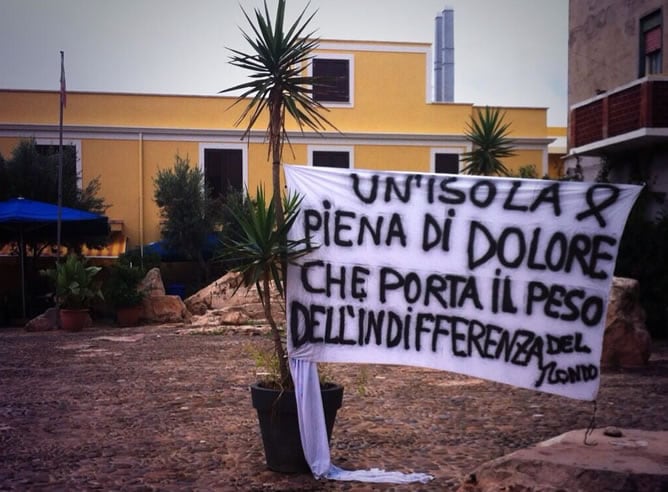 Una pancarta que reza: &quot;Una isla llena de dolor que lleva el peso de la indiferencia del mundo.&quot;