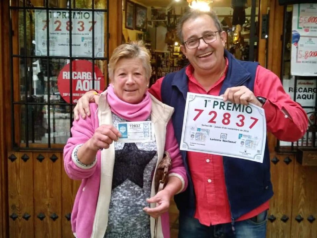 Maria posa feliz con su décimo de loteria premiado junto al dueño de la administración de la plaza de Santa María, Manuel Bello