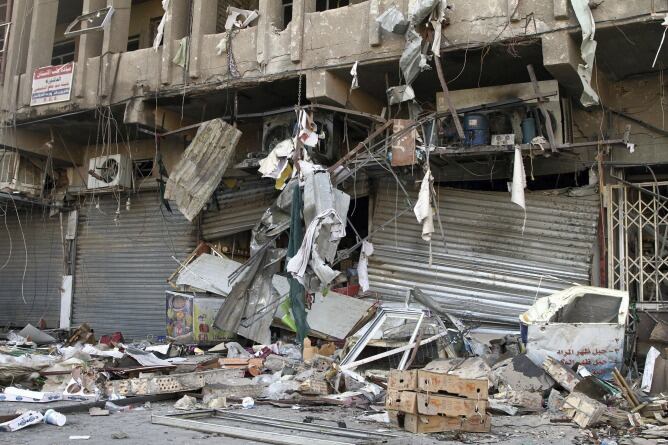 Vista de los daños registrados en varias tiendas en el lugar donde hizo explosión un coche bomba en el distrito de Al Karrada, en el centro de Bagdad