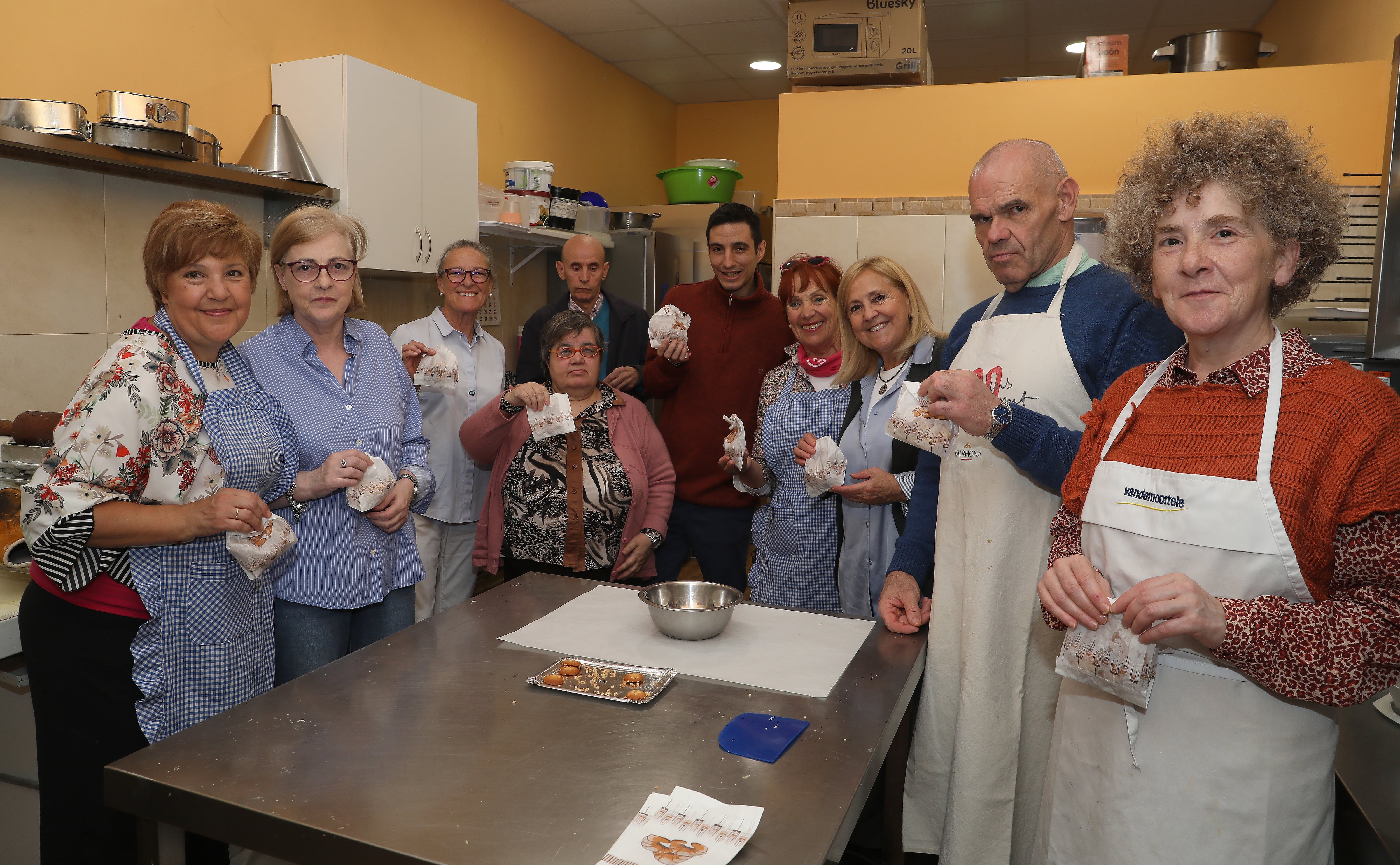 Las voluntarias María Antonia Rodríguez(3I), Eva Burón(I), Rosario Minguez(4D) ; y la coordinadora del voluntariado, Cecilia Presa(3D), junto a usurarios de Hermanas Hospitalarias tras finalizar el taller de pastelería en la La Casa del Pan Ayuela Burón