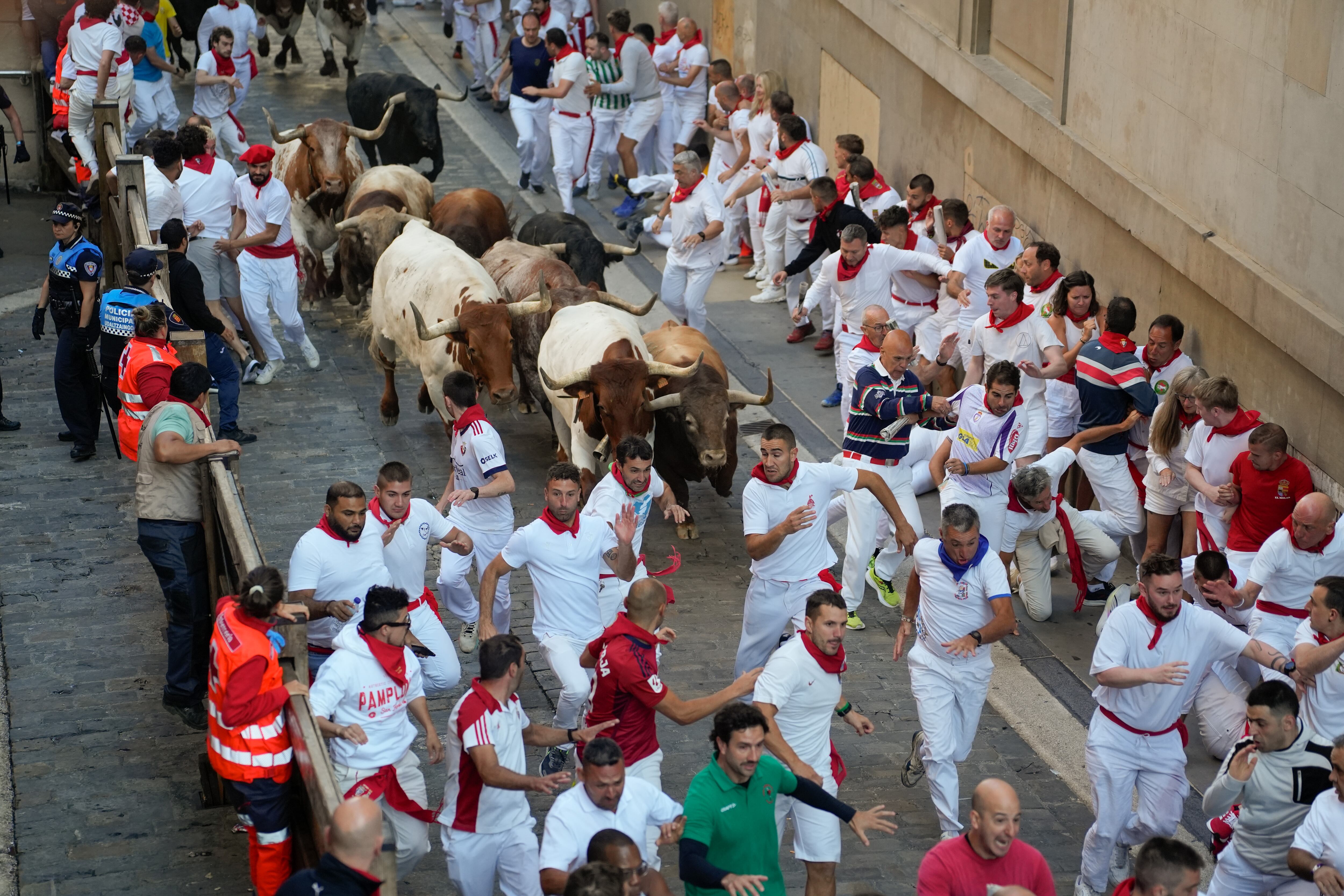 PAMPLONA, 10/07/2025.-Los mozos son perseguidos por los toros de la ganadería Victoriano del Río Cortés en el tramo del Ayuntamiento durante el cuarto encierro de los Sanfermines, este jueves, en Pamplona. EFE/Ainhoa Tejerina