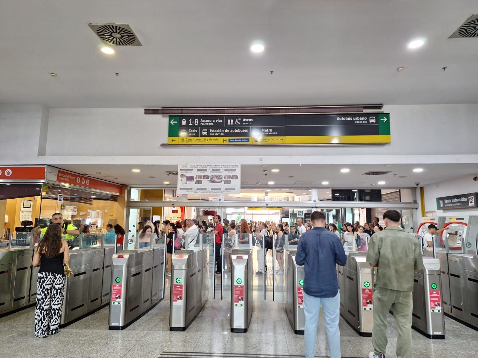 Tras los tornos de pago de los billetes, la cola ante la taquilla de Renfe en Málaga este lunes