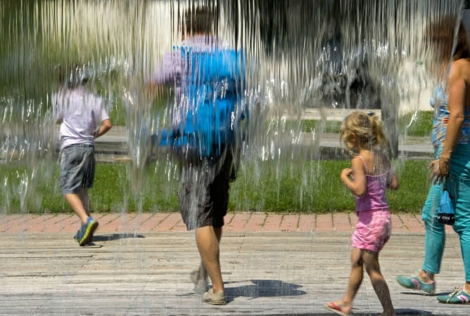 Una familia se refresca en una fuente de Pamplona ante el calor sofocante.