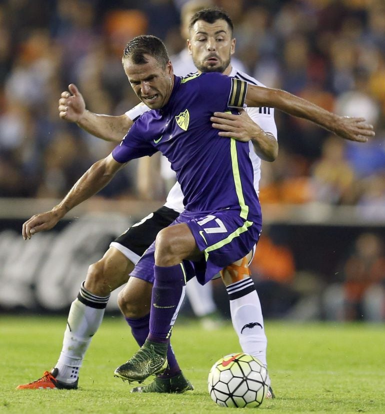 Duda intenta proteger el balón delante de Javi Fuego