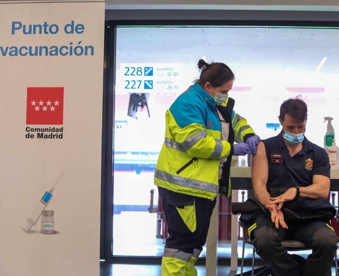 Una sanitaria vacuna a un bombero de la Comunidad de Madrid en el punto de vacunación contra el Covid-19 puesto en marcha en el Estadio Wanda Metropolitano, este jueves.